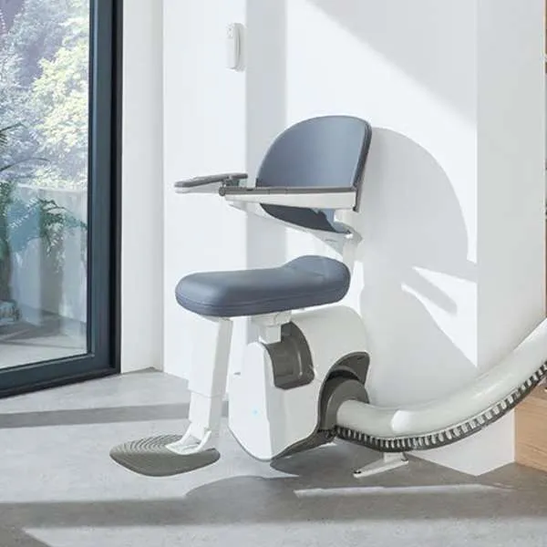 Access BDD Flow X Curved Stairlift bottom parked at the of the stairs
